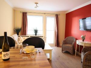 - un salon avec des murs rouges et une table dans l'établissement 2-Zimmer-Appartementin zentraler Lage, à Westerland