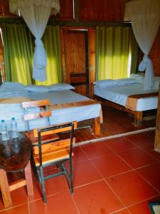 twee bedden in een kamer met een tafel en een stoel bij Hill home Hoang Su Phi in Nam Pi