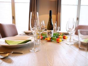 ein Tisch mit Gläsern und eine Flasche Wein darauf in der Unterkunft Ferienhaus mit neuen und sehr hochwertigen Appartements in zentraler Lage in Westerland in Westerland