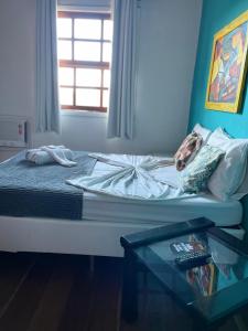 uma cama num quarto com uma mesa de vidro em Pousada Beluga em Búzios