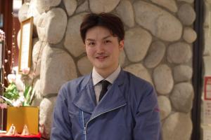 un hombre con traje y corbata posando para una foto en ITADAKI Daisen 大山参道ホテル頂, en Daisen