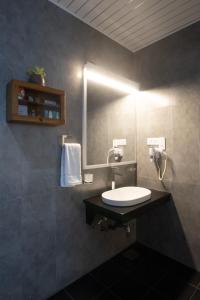 a bathroom with a sink and a mirror at Hotel Grand Turf By GSP in Nuwara Eliya
