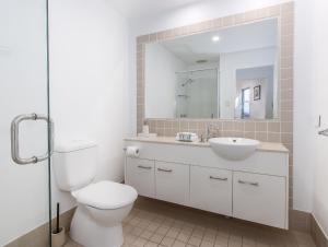 ein Badezimmer mit Toilette, Waschbecken und Spiegel in der Unterkunft Stunning She Oak Lane - 2 Bedroom Apartment! in Casuarina + 17 Fotos