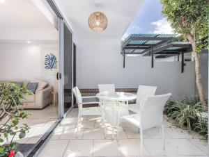 un patio con tavolo, sedie e divano di Stunning She Oak Lane - 2 Bedroom Apartment! a Casuarina