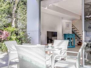 una sala da pranzo con sedie bianche e tavolo di Stunning She Oak Lane - 2 Bedroom Apartment! a Casuarina
