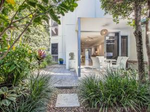 un patio esterno con sedie e piante bianche di Stunning She Oak Lane - 2 Bedroom Apartment! a Casuarina