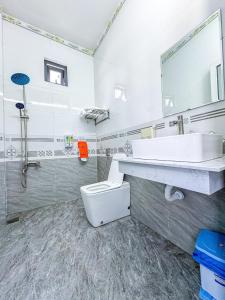 ein weißes Bad mit einem Waschbecken und einem WC in der Unterkunft homestay Phúc Lũy in Cu Lao Thu