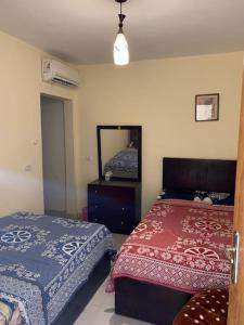 a bedroom with two beds and a mirror at Poolside serenity in El Alamein +15 photos