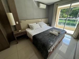 a bedroom with a bed with two towels on it at Alugueasy - Brisas do Lago in Brasilia