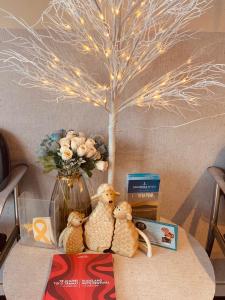 dos animales de peluche sentados en una mesa junto a un árbol en Ocean Inn Motel, en Auckland