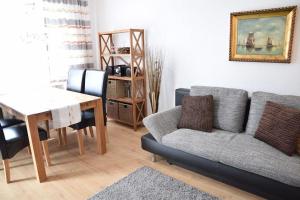 ein Wohnzimmer mit einem Sofa und einem Tisch in der Unterkunft Die 2 Zimmerwohnung mit Balkon liegt in der 1 Etage und ist ideal für 2 bis 3 Personen in Westerland
