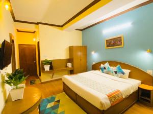 een slaapkamer met een bed en een bureau in een kamer bij Hotel Tara INN with terrace and mountain view in Shimla