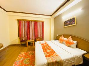 ein Schlafzimmer mit einem großen Bett und einem Fenster in der Unterkunft Hotel Tara INN with terrace and mountain view in Shimla