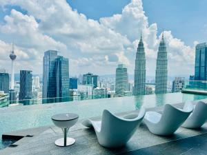 a pool with chairs and a view of a city at Imperial lexis KLCC By AR Hospitality in Kuala Lumpur