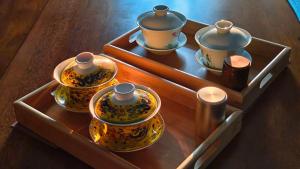 a wooden tray with four tea pots and cups on it at 一個人背包客棧 in Wujie