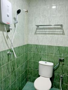 e bagno piastrellato verde con servizi igienici e doccia. di HOTEL SAHARA INN TANJUNG MALIM a Kampong Chabang