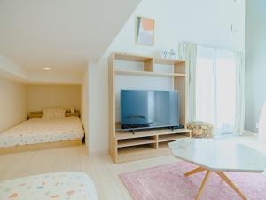 een woonkamer met een bed en een televisie bij YOUR ROOM Kumamoto Sta little 203 Vacation STAY 75726 in Kumamoto