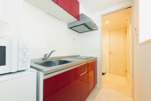 uma cozinha com um lavatório e um micro-ondas em YOUR ROOM Kumamoto Sta little 201 Vacation STAY 75222 em Kumamoto