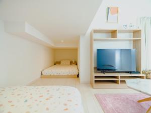 een slaapkamer met een bed en een flatscreen-tv bij YOUR ROOM Kumamoto Sta little 203 Vacation STAY 75726 in Kumamoto