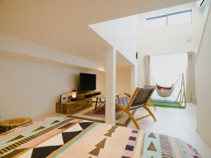 um quarto com uma cama, uma televisão e uma cadeira em YOUR ROOM Kumamoto Sta little 201 Vacation STAY 75222 em Kumamoto