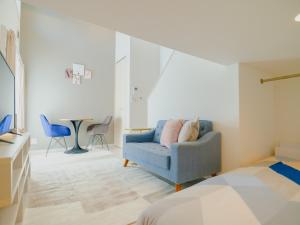 1 dormitorio con sofá azul y mesa en YOUR ROOM Kumamoto Sta little 103 Vacation STAY 75704, en Kumamoto