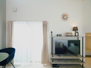 een woonkamer met een televisie en een stoel bij YOUR ROOM Kumamoto Sta little 202 Vacation STAY 75720 in Kumamoto
