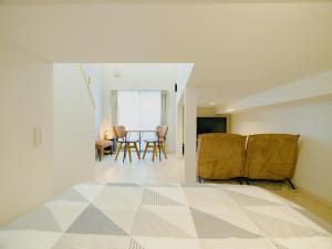 een witte kamer met een tafel en stoelen. bij YOUR ROOM Kumamoto Sta little 105 Vacation STAY 39911 in Kumamoto
