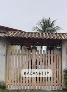 un cartel en una valla de madera frente a una casa en Condomínio Santa Rosa, en Caraguatatuba
