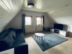 a living room with a couch and a table at Appartement Dümmer Seeblick in Hüde