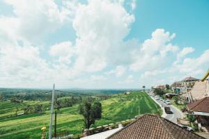 una vista de una carretera en una ciudad con campos verdes en Bhuana Agung Villa and Restaurant by ecommerceloka, en Jatiluwih