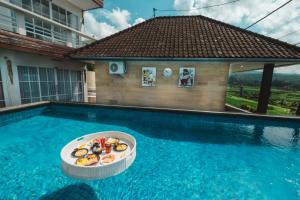 una piscina con una bañera de comida. en Bhuana Agung Villa and Restaurant by ecommerceloka, en Jatiluwih
