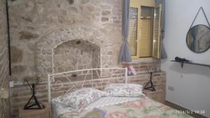 馬拉瑟亞斯的住宿－HARI'S NEST CORFU，一间卧室设有一张床和石墙