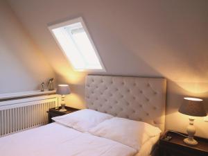 韋斯特蘭的住宿－Bundiswung 9 Whg. 5, GB2，一间卧室配有一张带天窗的大床
