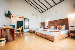 una camera da letto con un letto grande e un tavolo di Samudra Beach Resort a Tangalle Altre 37 foto