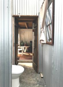an open door to a bathroom with a toilet at Dreamer Cabin Tre house Dalat in Da Thien
