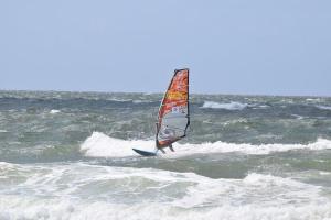 uma pessoa está a praticar windsurf no oceano em Im Zentrum von Westerland gelegene Ferienwohnung mit Westbalkon und schönem Ausblick em Westerland