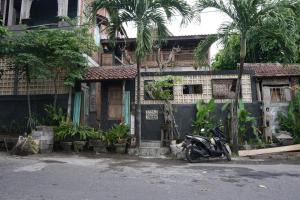 金巴蘭的住宿－TwoSpaces Living at Bunga Desa, Jimbaran，停在大楼前的摩托车