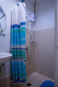 W łazience znajduje się prysznic z zasłoną prysznicową. w obiekcie S&S Condostay w mieście Cagayan de Oro