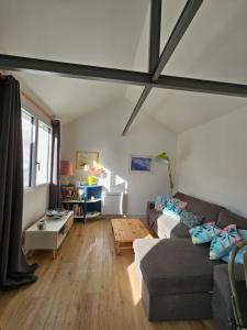 a living room with a couch and a table at Deux maisons reunis par le jardin et sa cabine de plage, à 8min à pieds des plages et de l'océan in Batz-sur-Mer