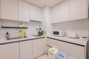 a white kitchen with a sink and a microwave at Mirae stay 67 in Seoul