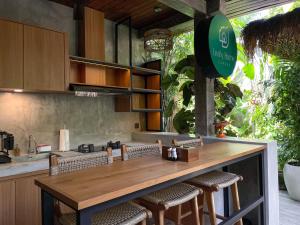 uma cozinha com um balcão com cadeiras e um balcão em Leafy Home Canggu em Canggu