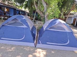 two blue tents are parked in a yard at Two Rocks Bungalows in Baan Tai
