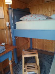 łóżko piętrowe w drewnianym pokoju ze stołem w obiekcie Hütte Krötenhof, Radfahrer Übernachtung w mieście Barförde