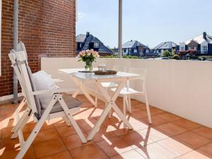 een witte tafel en 2 stoelen op een balkon bij Nordmarkstraße 20, W21 Gestrandet in Westerland