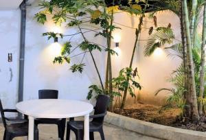 una mesa blanca y sillas en una habitación con árboles en Casa Selva Viva, en Tarapoto