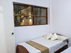 Cama en habitación con ventana en Casa Selva Viva, en Tarapoto