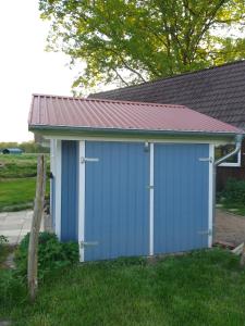 a blue garage with a metal roof at Hütte Krötenhof, Radfahrer Übernachtung in Barförde