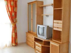 - un salon avec une télévision sur une commode en bois dans l'établissement Apartamentos Ambar Beach Unitursa, à Calp