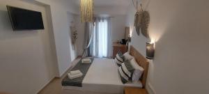 a white room with a bed and a window at Selinopetra Rooms in Elafonisos