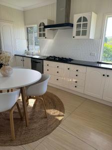 a kitchen with a white table and a white counter top at 3 bed room house near airport in North Ward